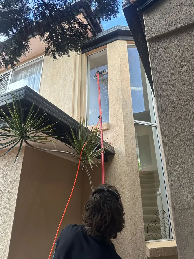 Cleaning a second-storey window on the Gold Coast in Clear Island Waters, Gold Coast